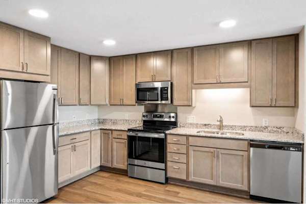 A kitchen with wooden cabinets and stainless steel appliances.