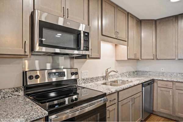 A kitchen with a stove, microwave, and oven.