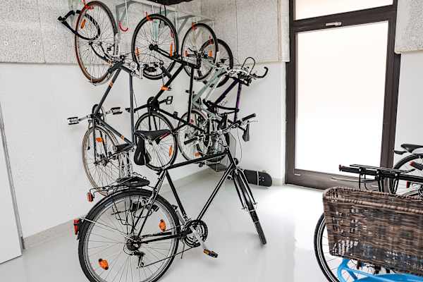 A bunch of bicycles are hanging on a wall.