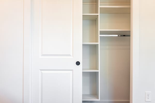 A white door with a shelf on the other side.