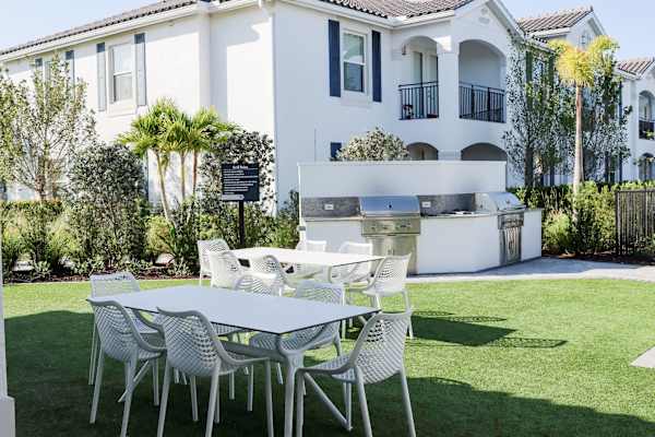 a table and chairs on a lawn in front of a house at The Crest at Naples, Naples, Florida