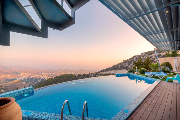 a swimming pool with a view of a city at sunset