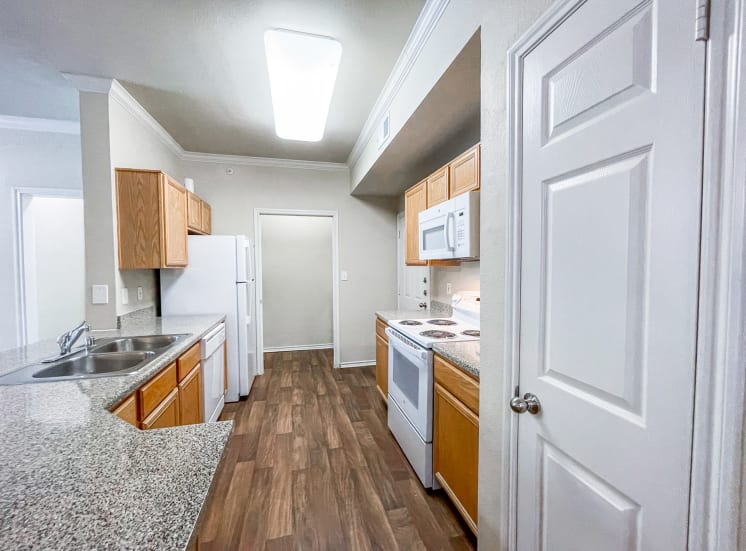 Open kitchen floor plan leading into a private laundry room at Gates de Provence Apartments in North Dallas, TX.