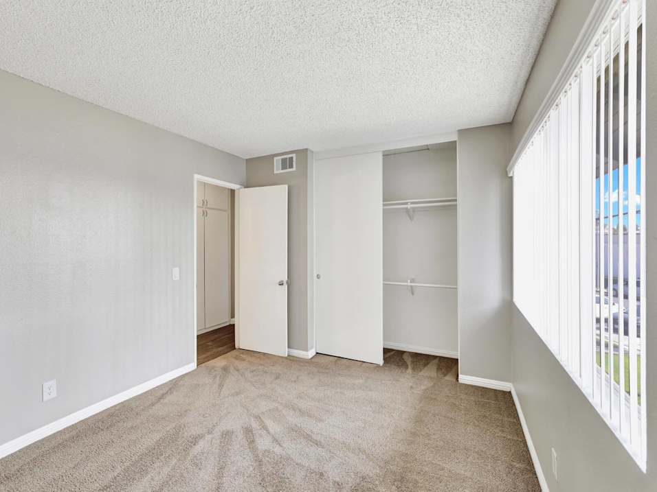 A room with a carpeted floor and a sliding door.