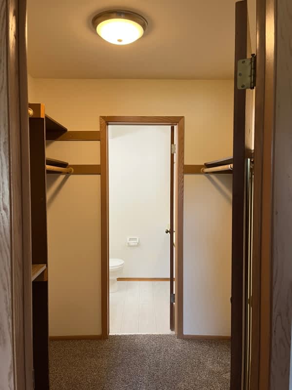 A bathroom with a toilet and sink is visible through an open door.