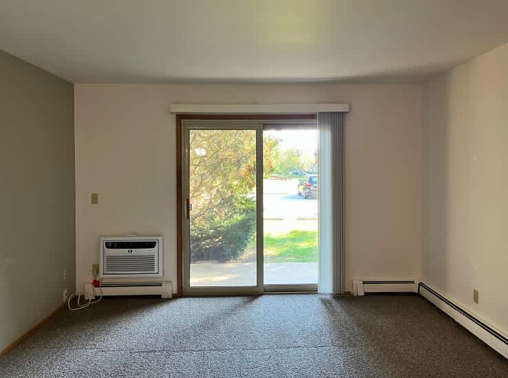 A room with a window and sliding glass door.