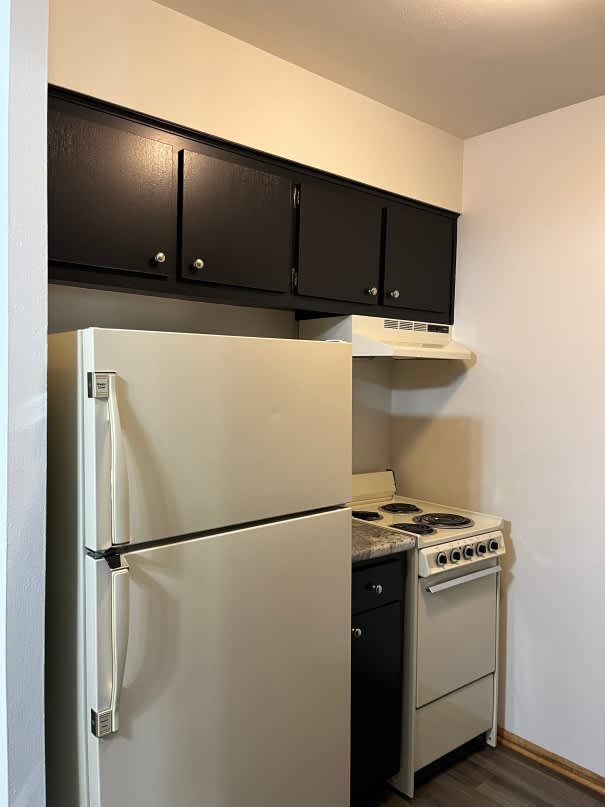 A white refrigerator and stove in a small kitchen.
