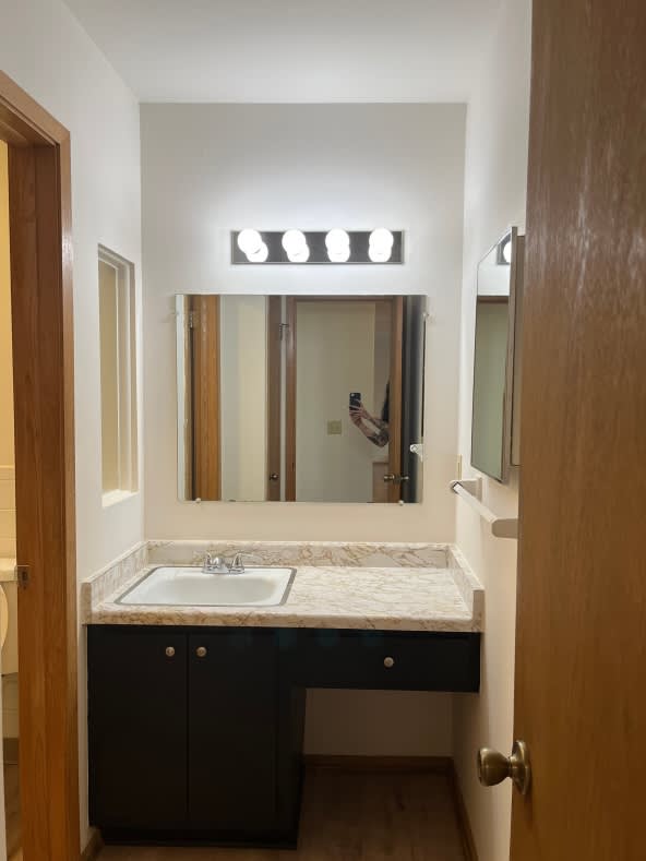 A bathroom with a sink and mirror.
