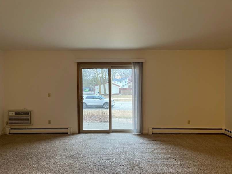 A room with a car parked outside the window.