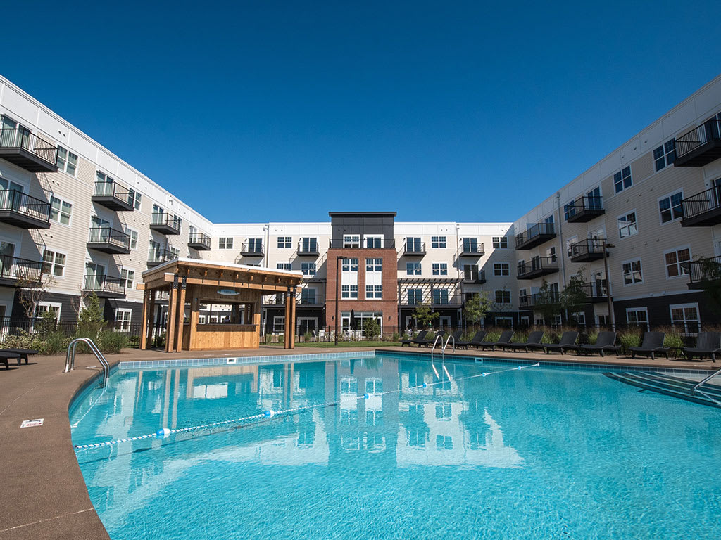 2-Bedroom Apartments in Lewis Center, OH - MIrada - Resort-Style Swimming Pool with Lounge Chairs, a Bar, and Maintained Landscaping