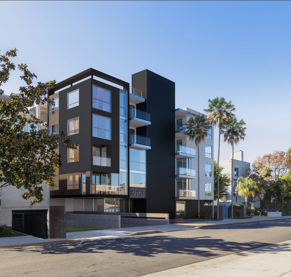 a tall building with a street in front of it and palm trees