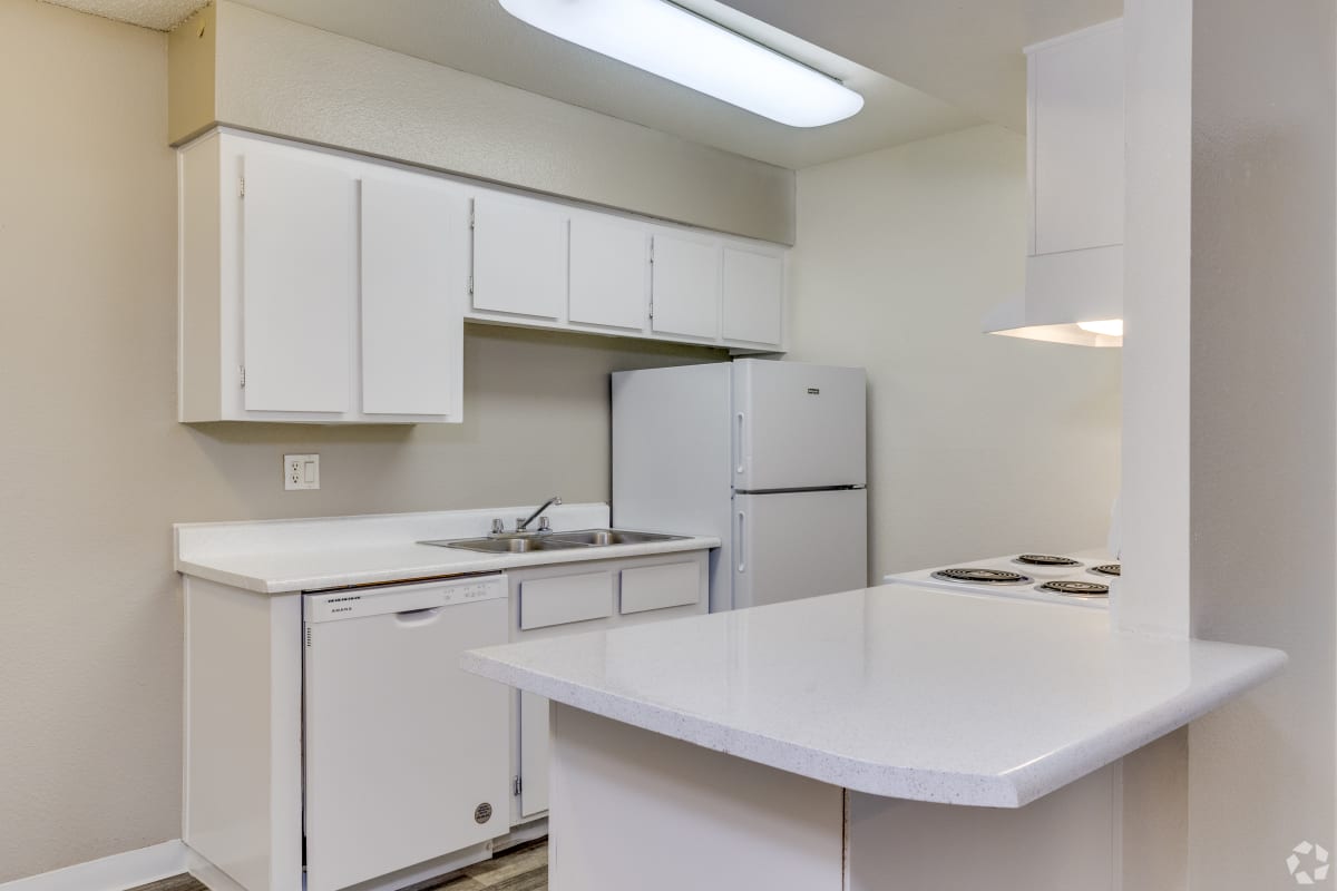 Kitchen with white cabinets and breakfast counter at Sagewood Apartments