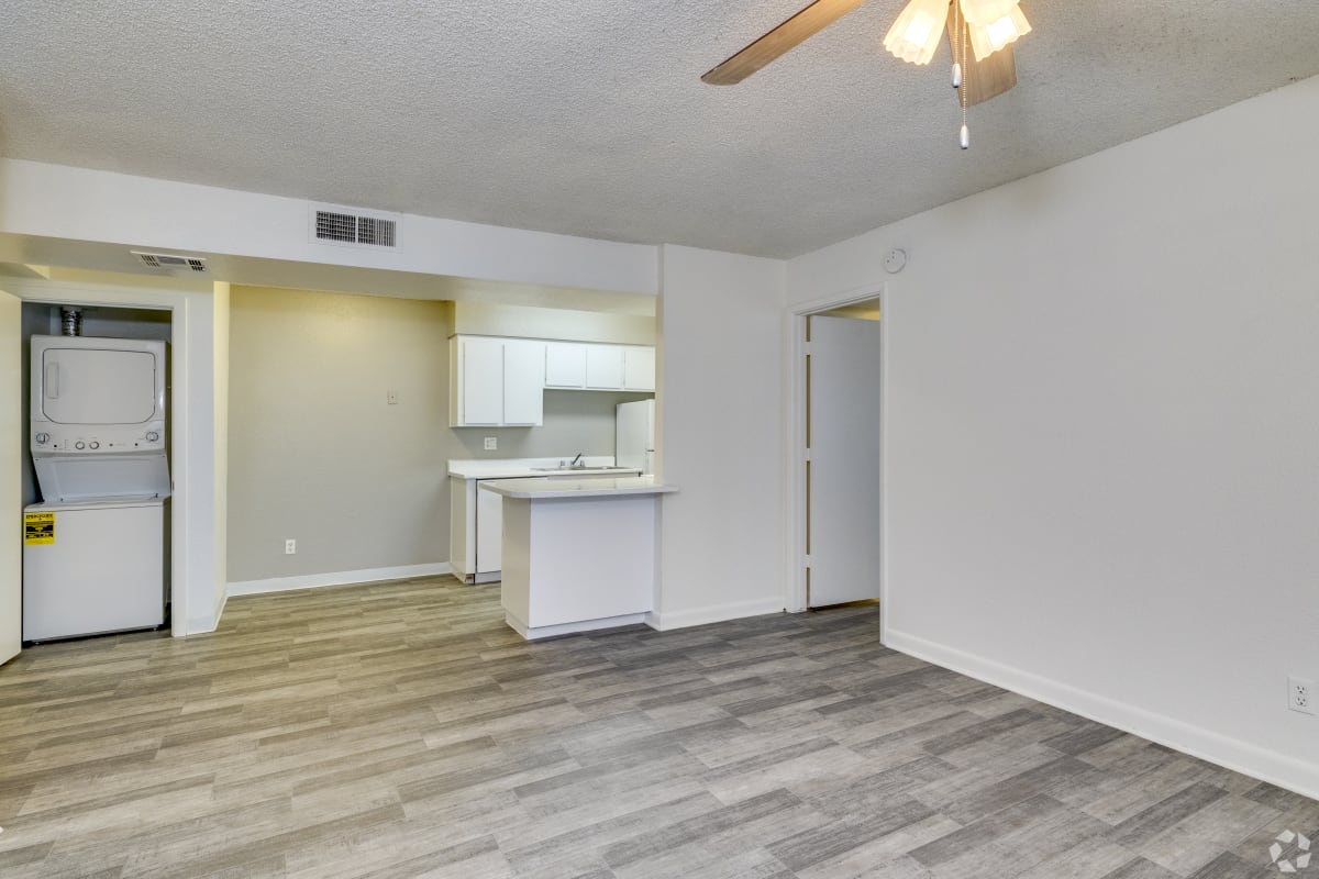 Living area beside the kitchen and stacked laundry at Sagewood Apartments