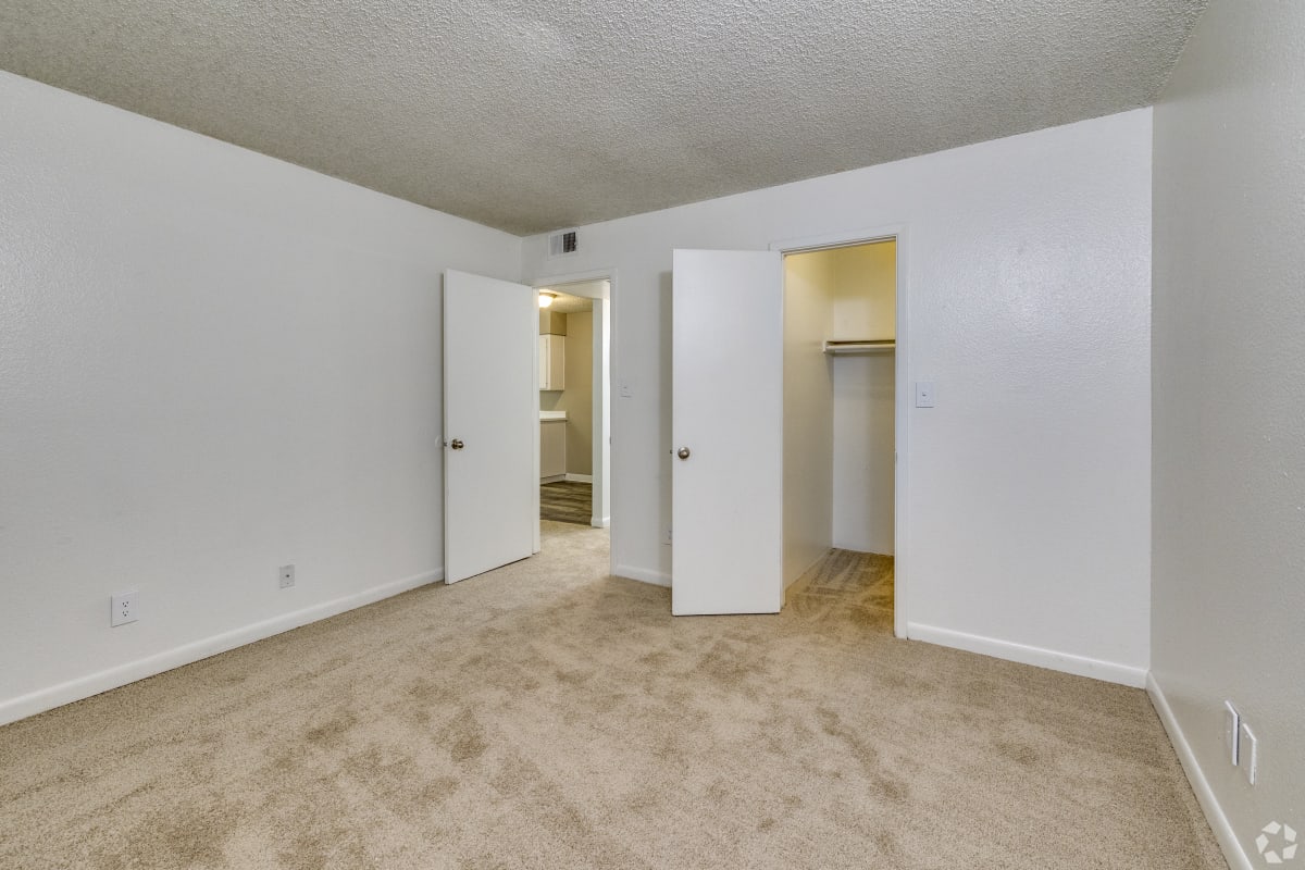 Carpeted bedroom with closet and bathroom access at Sagewood Apartments