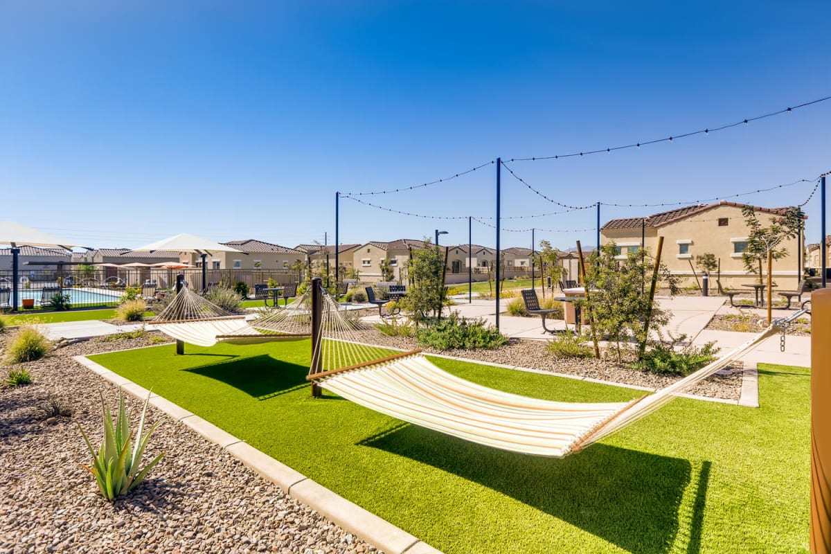Hammocks over turf beside landscaped paths.