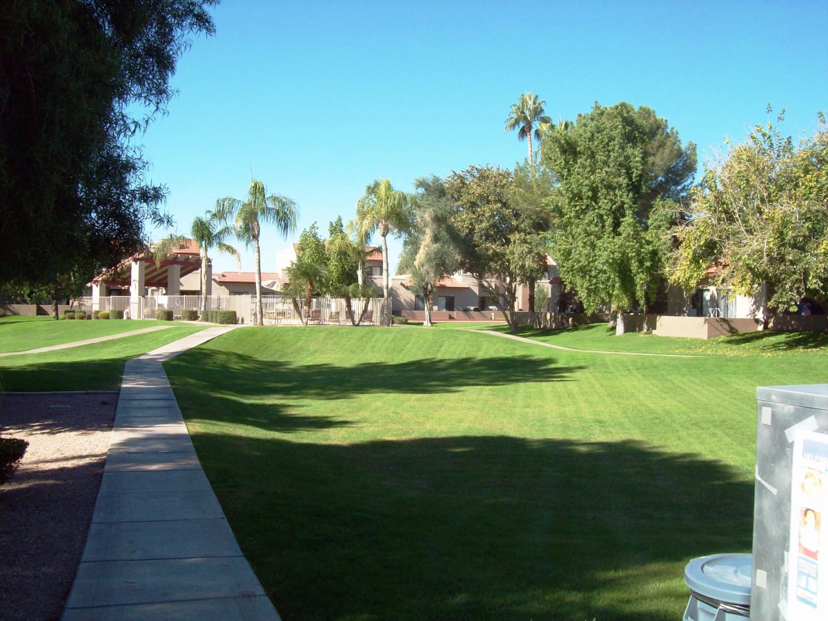 Landscaped community lawn and walking path at Acoma Thunderbird Townhomes