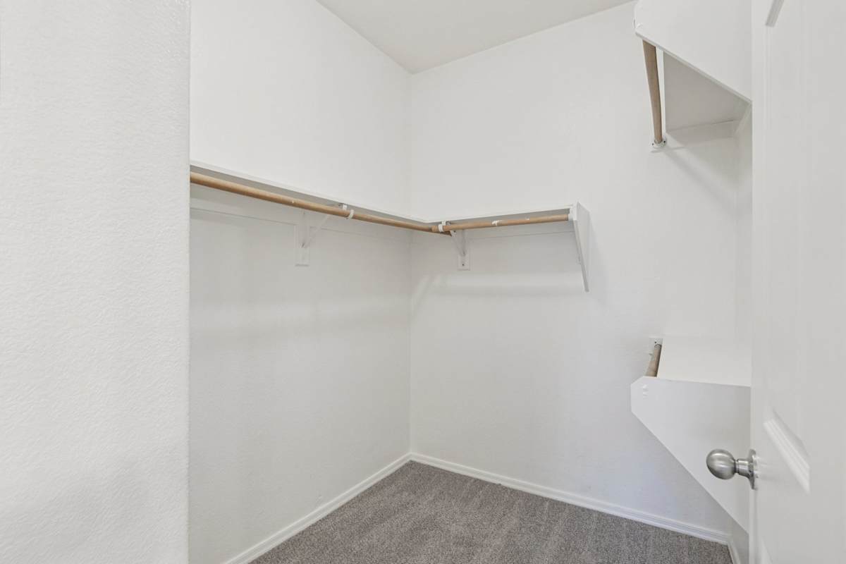 Closet with wraparound hanging rails and shelves.