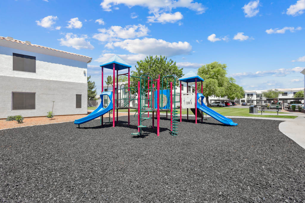 Playground with blue slides and climbing equipment.