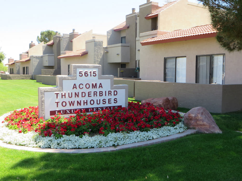 Entrance sign beside the flower bed at Acoma Thunderbird Townhomes