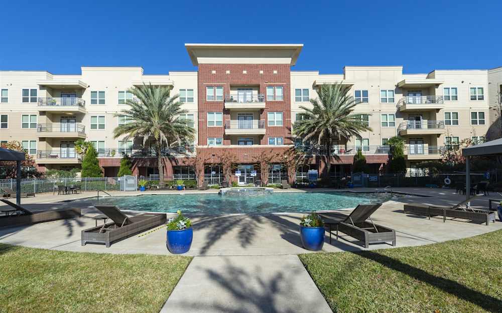 The swimming pool and deck with the apartment buildings behind
