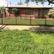 a brick house with a fence in front of it