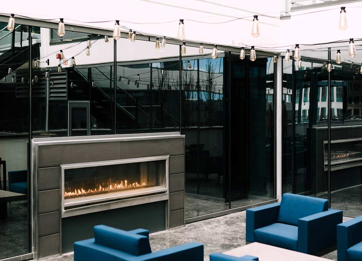 a modern living room with blue couches and a fireplace at The Grand Central, Chicago