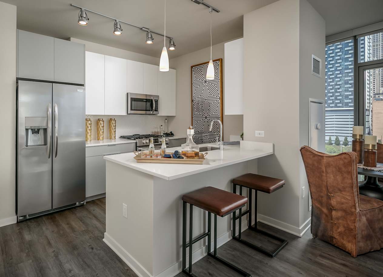 a kitchen with a large island and stainless steel refrigerator at The Grand Central, Illinois, 60607