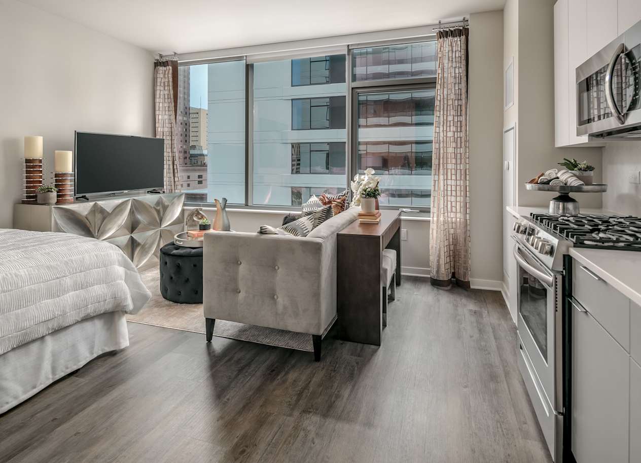 a living room with a large window and a kitchen with a stove at The Grand Central, Illinois