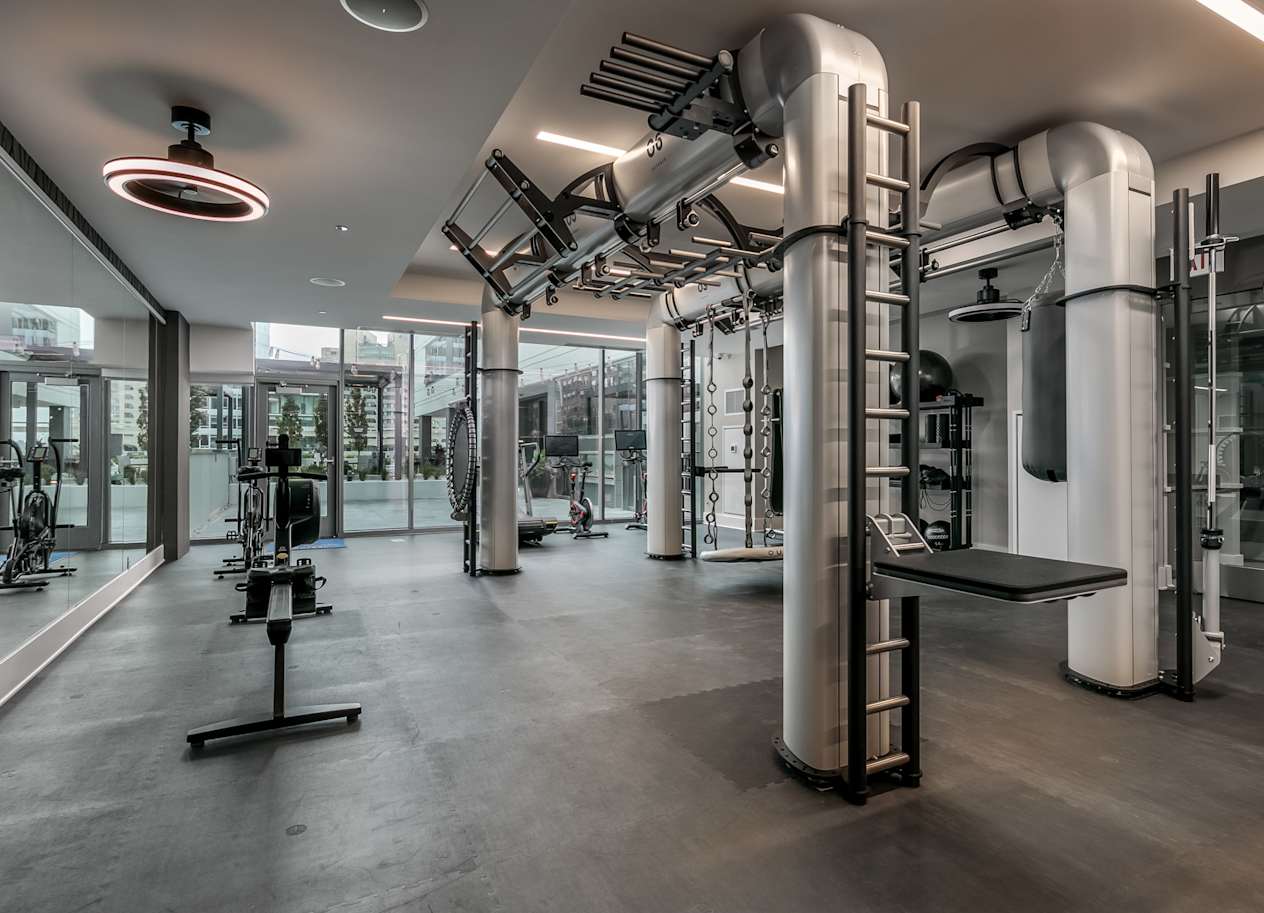 a workout room with equipment and pipes in a building at The Grand Central, Chicago, IL 60607