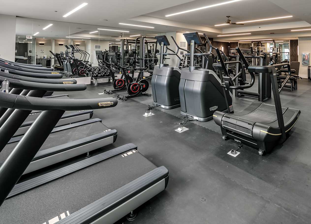 a gym with cardio equipment and weights on the floor at The Grand Central, Chicago