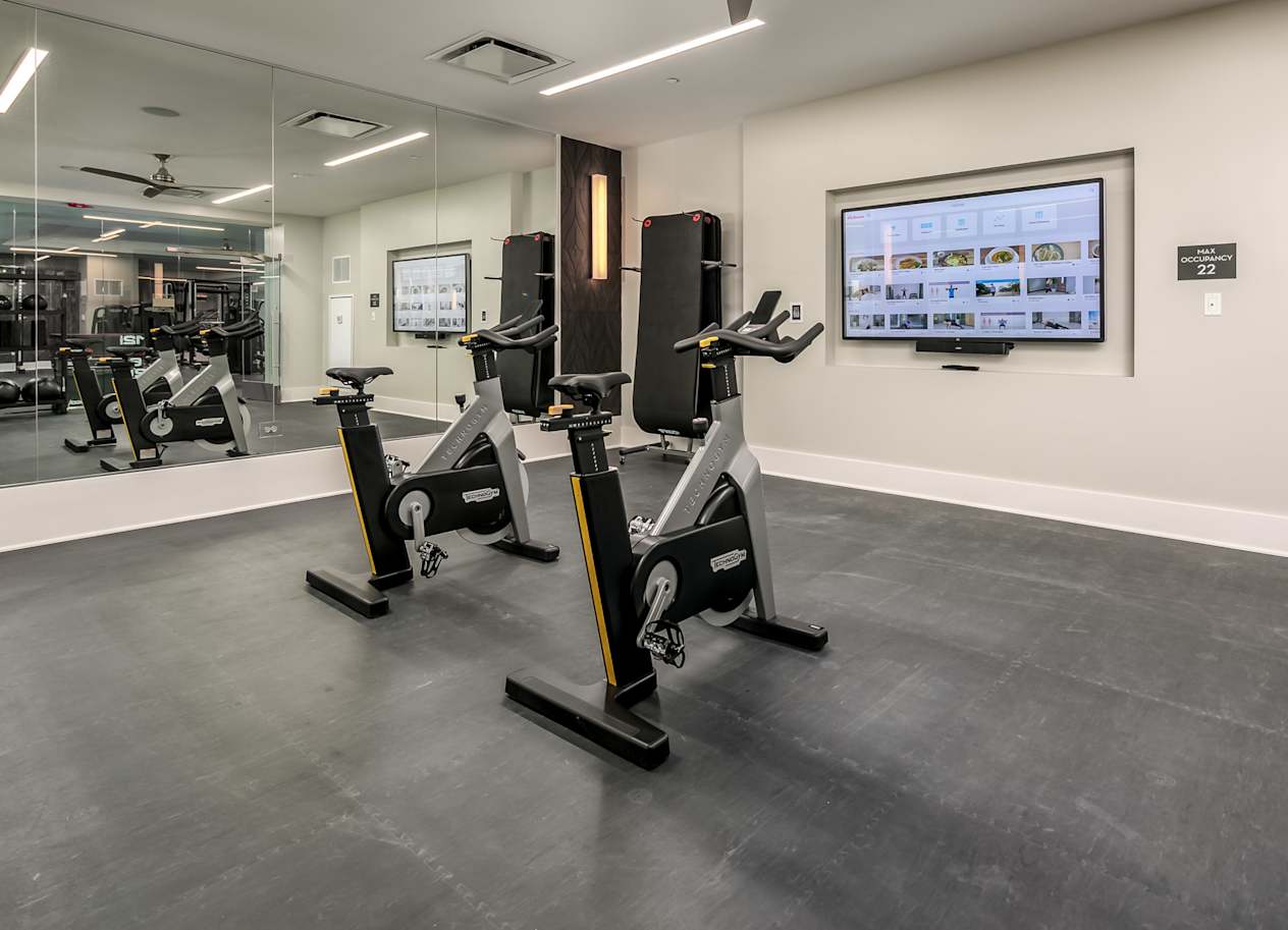 a gym with treadmills and other exercise equipment in a room with a tv at The Grand Central, Illinois