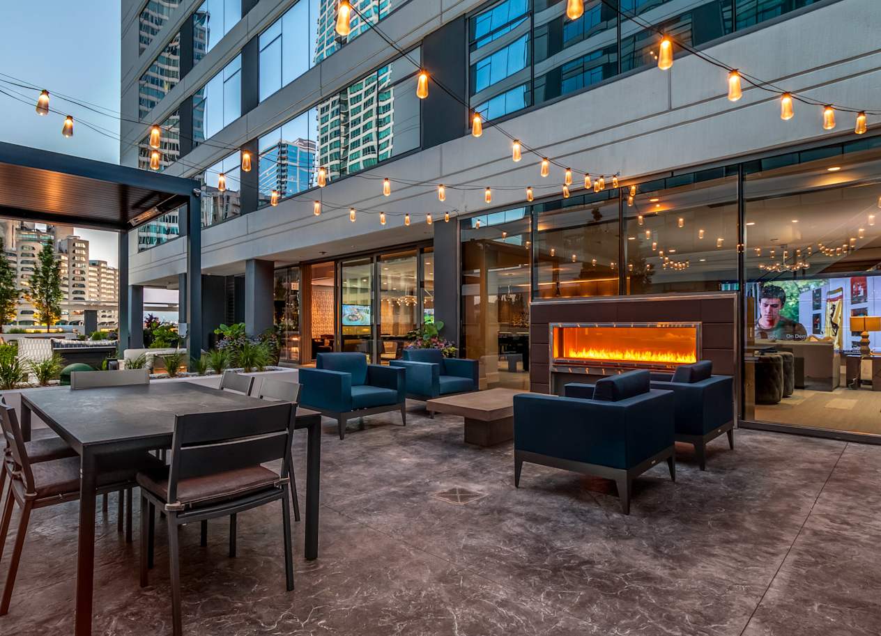 a lounge area with tables and chairs and a fireplace at The Grand Central, Chicago, IL