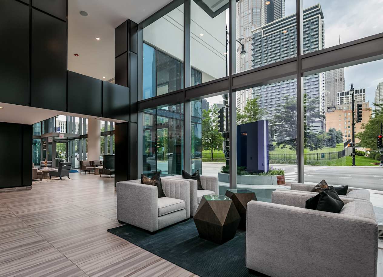the living room has floor to ceiling windows and views of the city at The Grand Central, Chicago Illinois