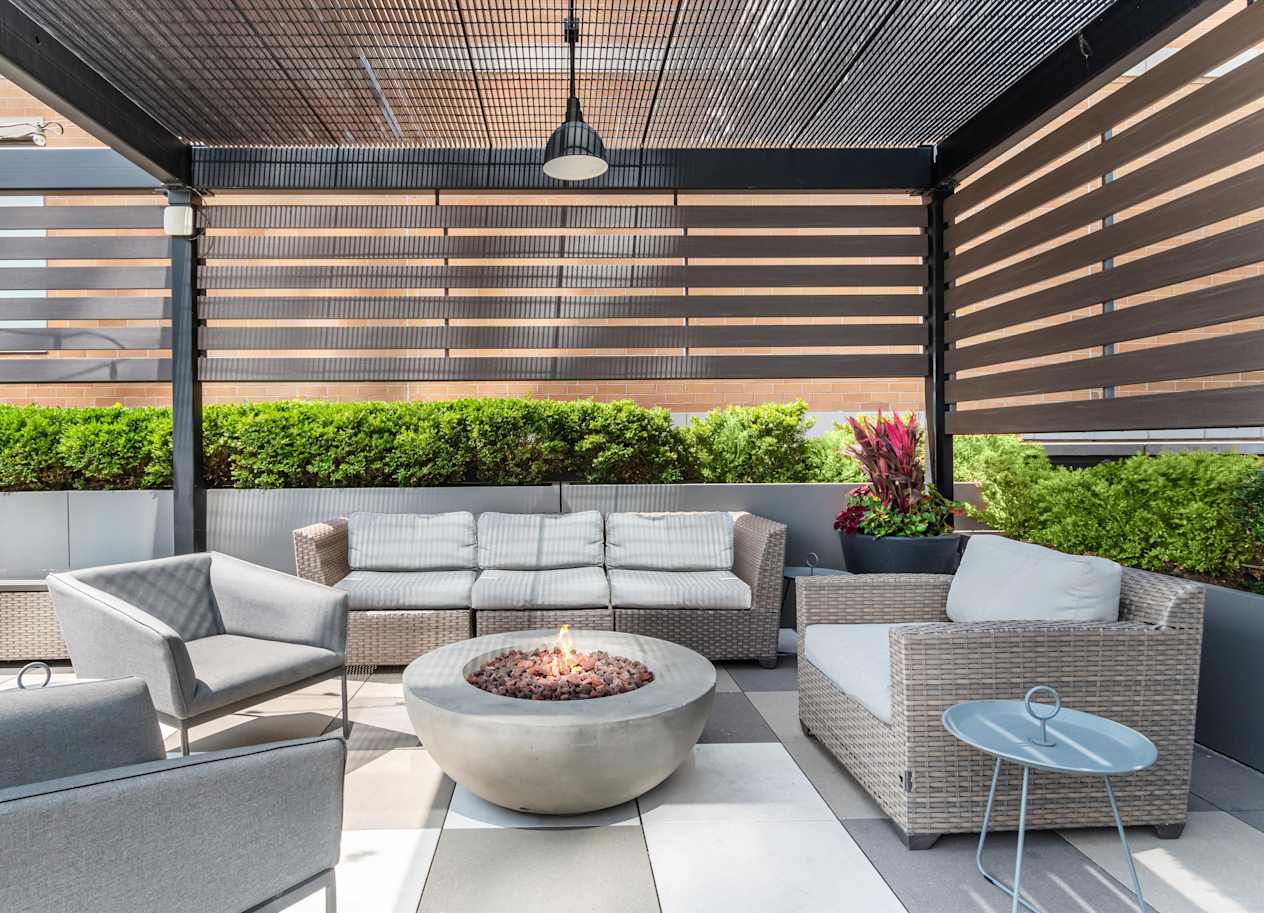 A patio with a fire pit and seating area.