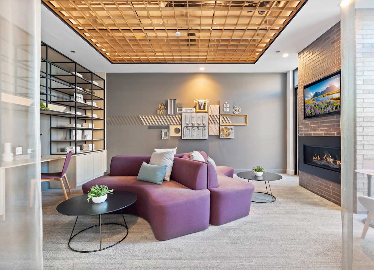 a living room with a purple couch and a fireplace