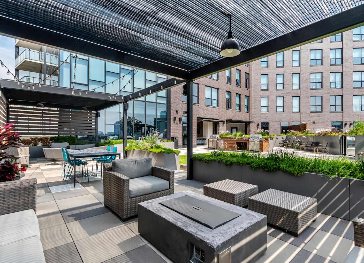 A patio with a table and chairs under a roof.