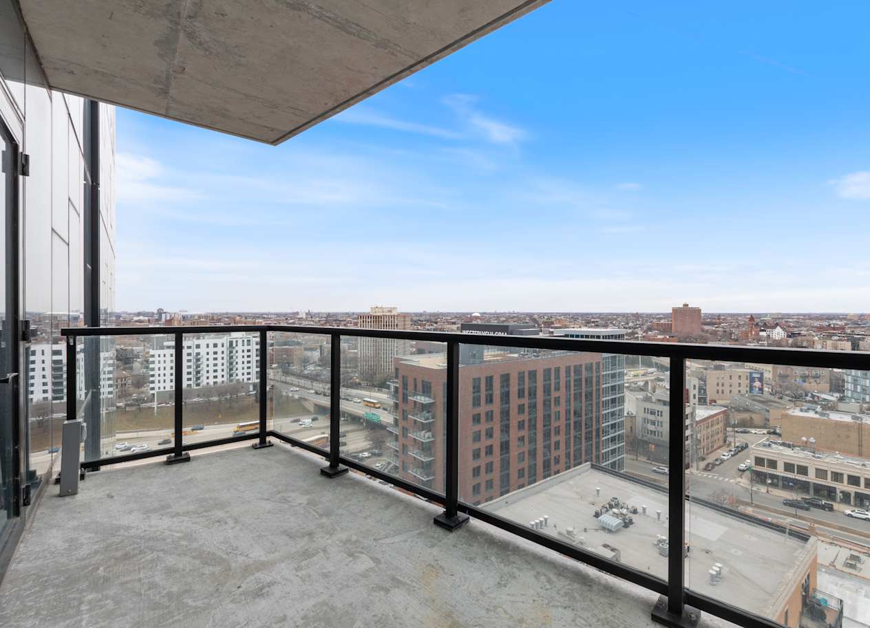a balcony with a view of a city and a blue sky