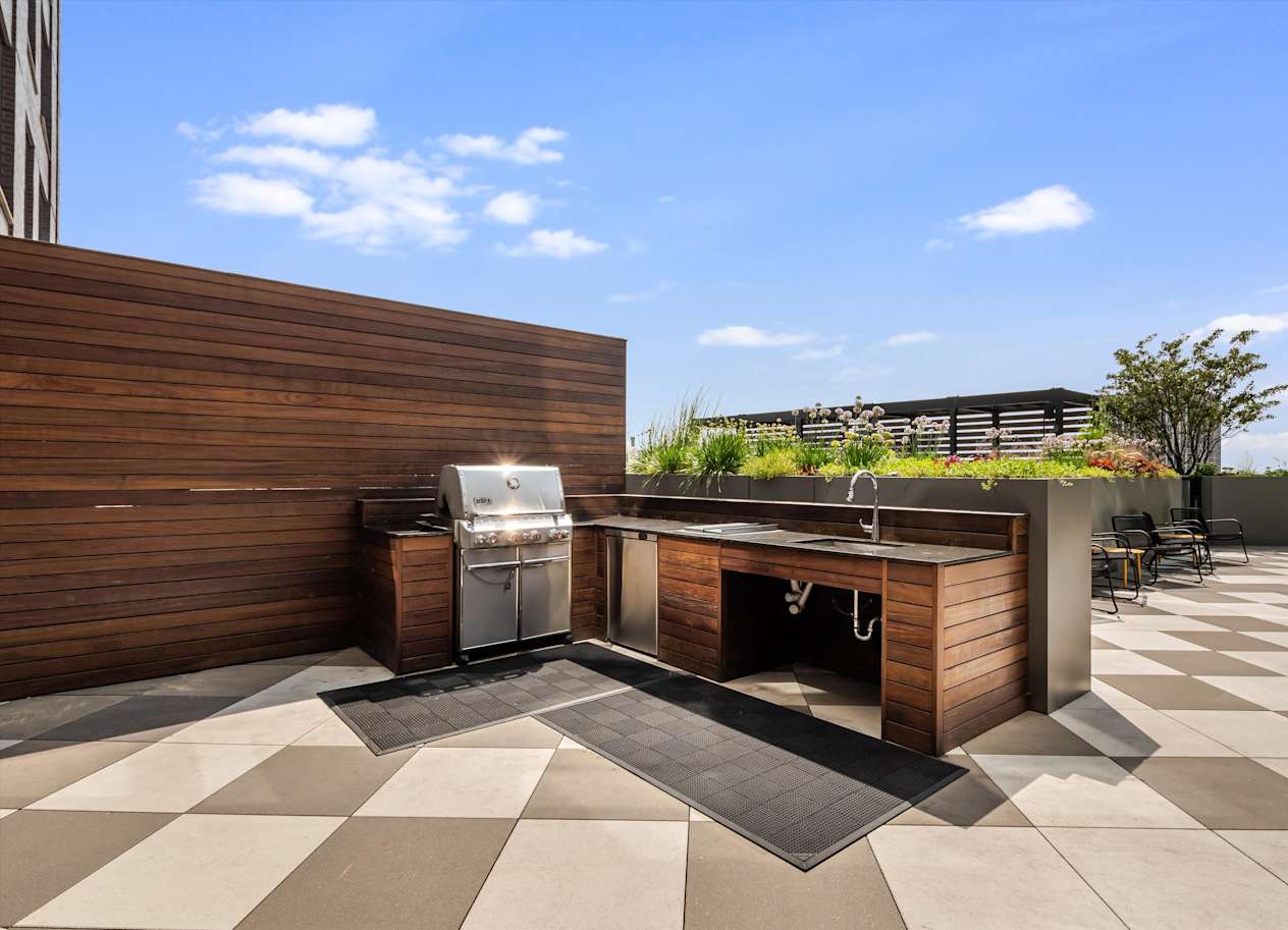 A modern outdoor kitchen with a grill and sink.