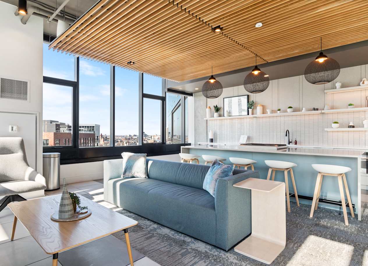 a living room with a blue couch and a kitchen with a table and chairs