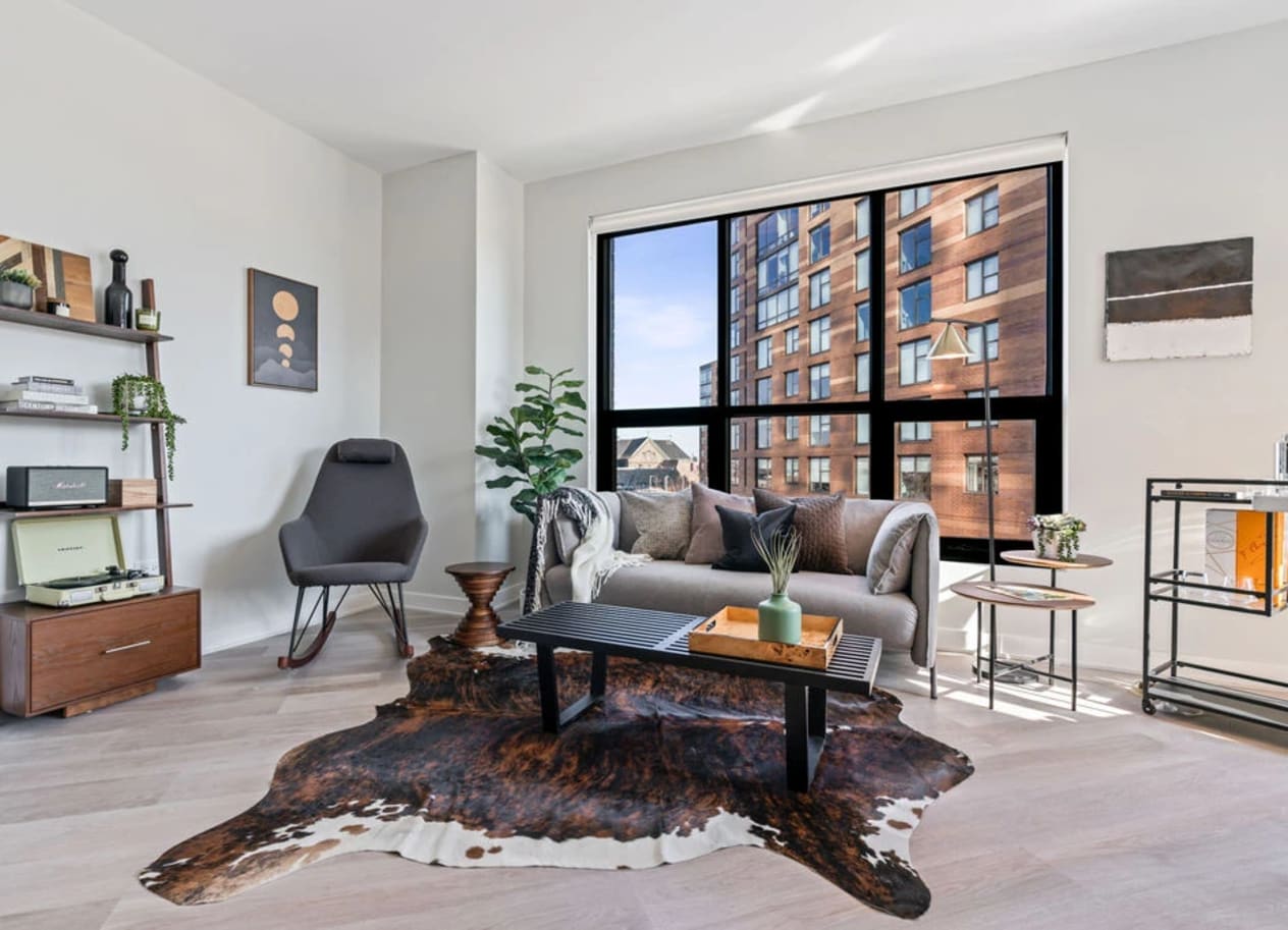 a living room with a large window and hardwood floors