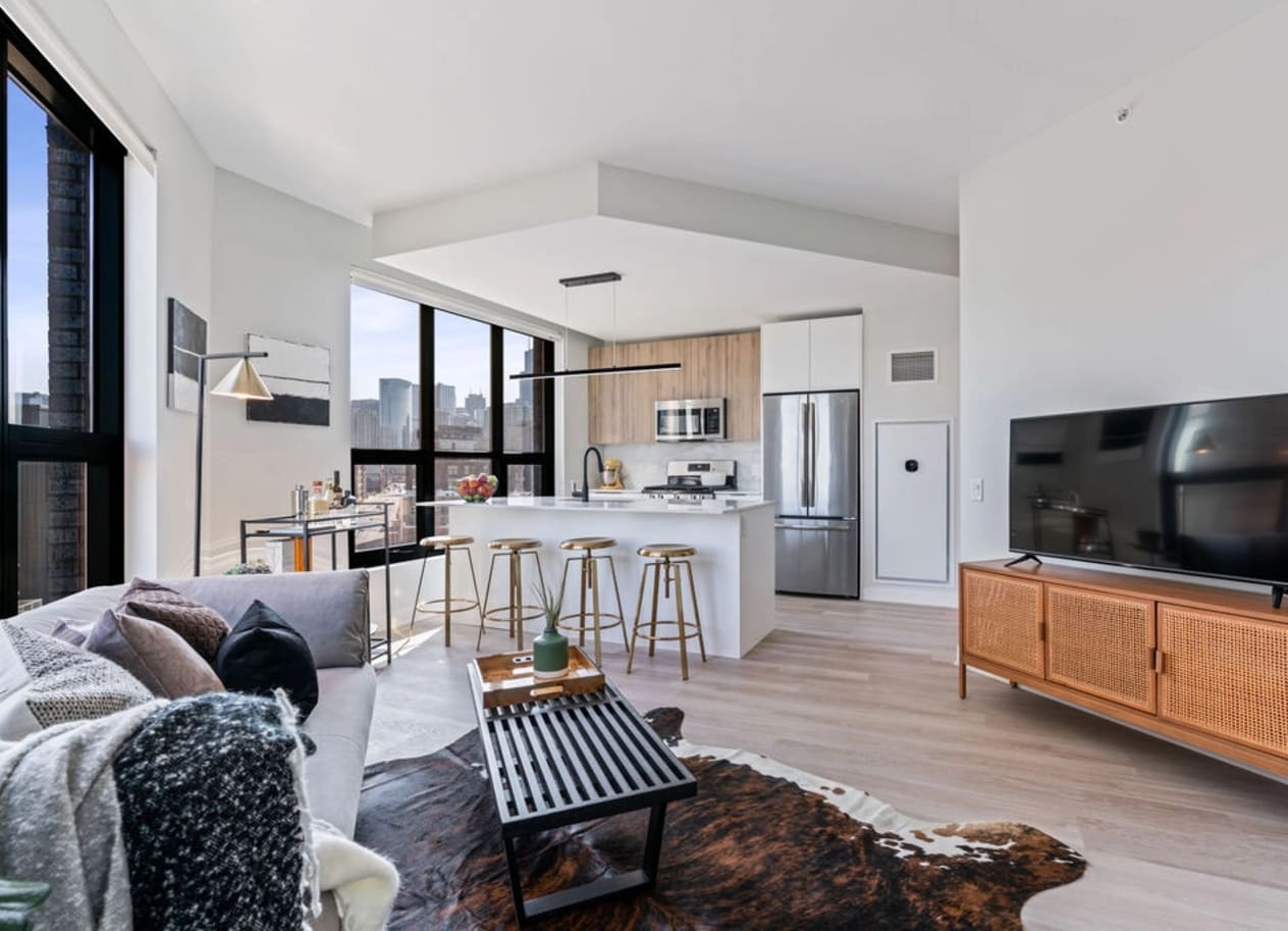 a kitchen and living room with white walls and hardwood floors