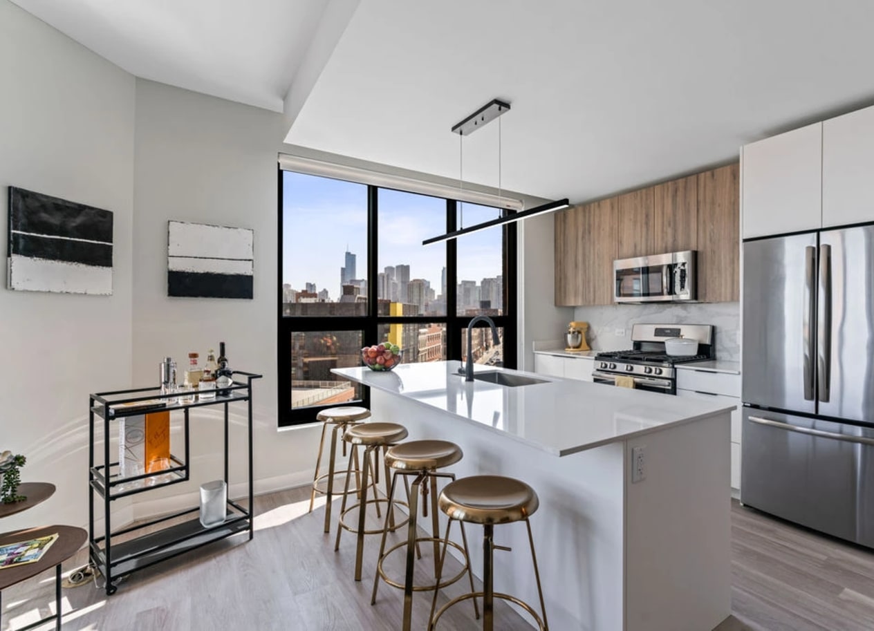 a kitchen with a large center island with a breakfast bar and stools