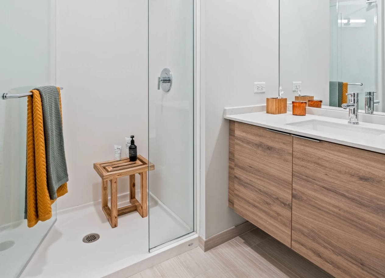 a bathroom with white walls and wood flooring