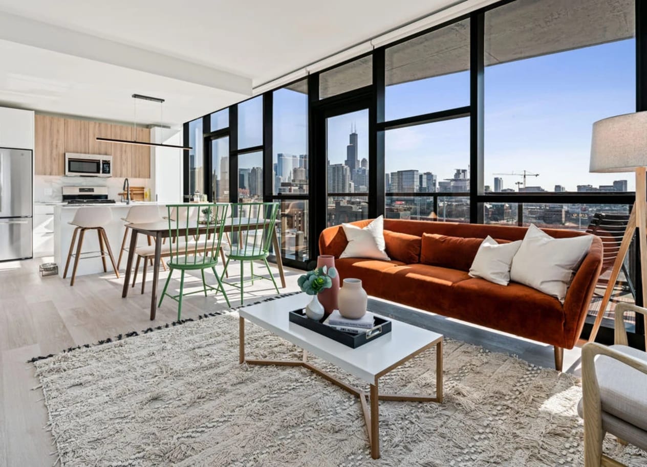 a living room with a brown couch and a table with a vase on top of it