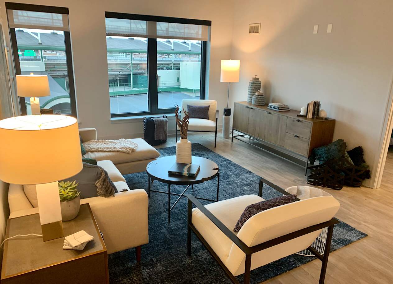 a living room with white furniture and a large window at Residences at Addison Clark Apartments, IL, 60613