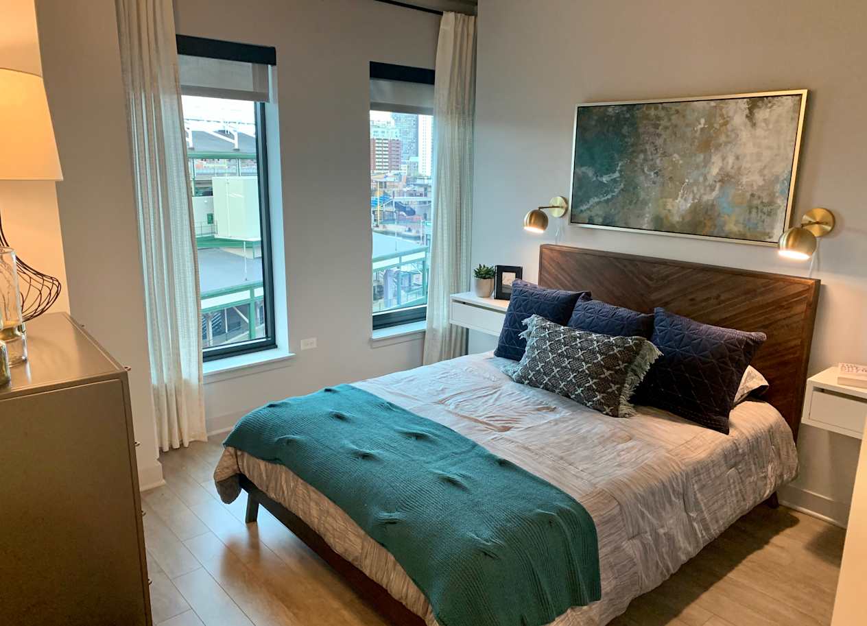 a bedroom with a bed and a large window at Residences at Addison Clark Apartments, Chicago, IL, 60613