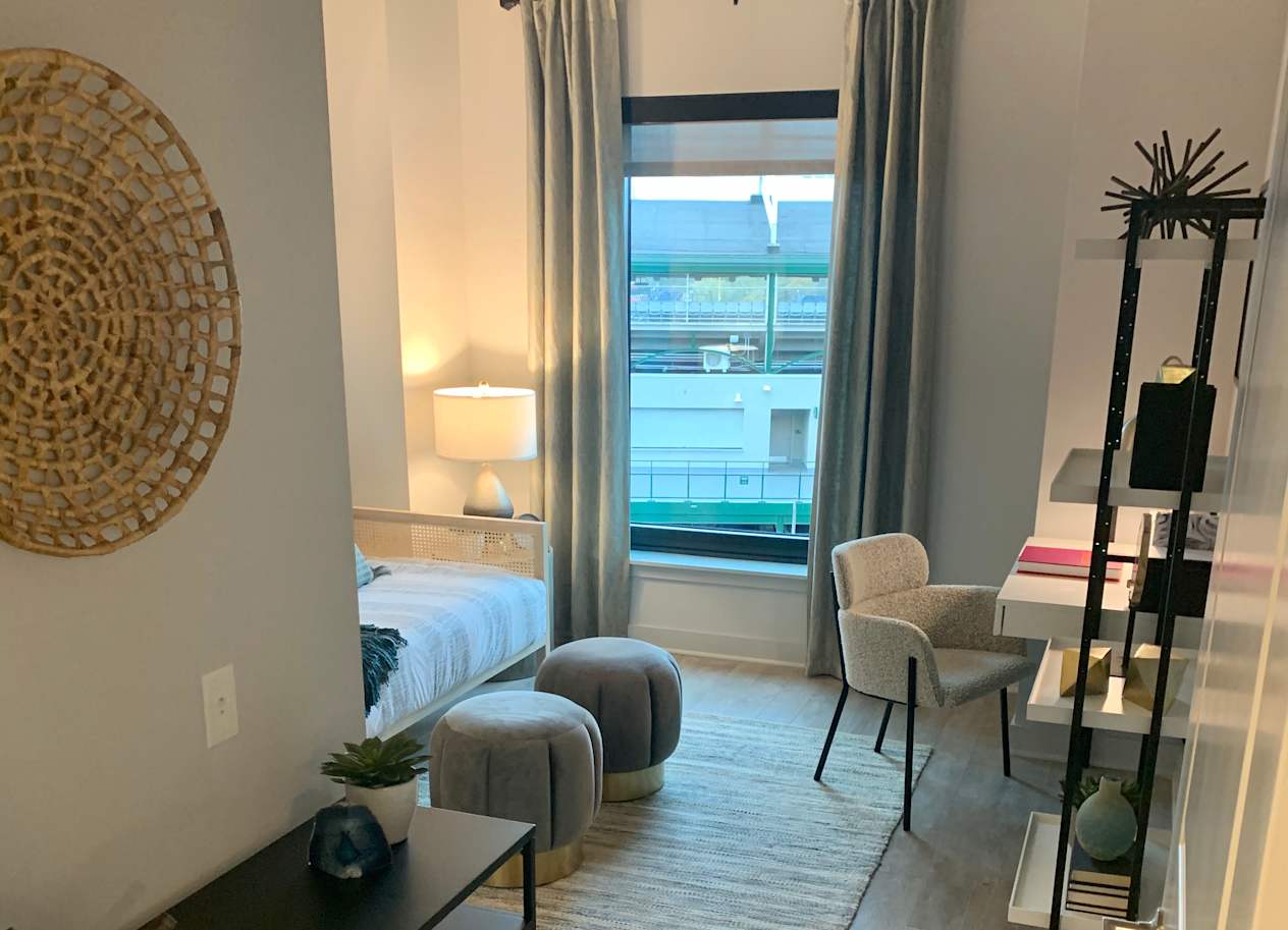 a living room with a bed and a sliding glass door at Residences at Addison Clark Apartments, Chicago, IL, 60613