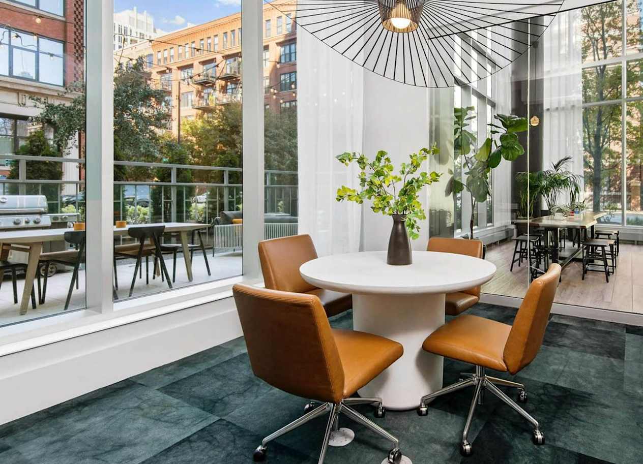 a dining area with a table and four chairs and a large window with a view of a