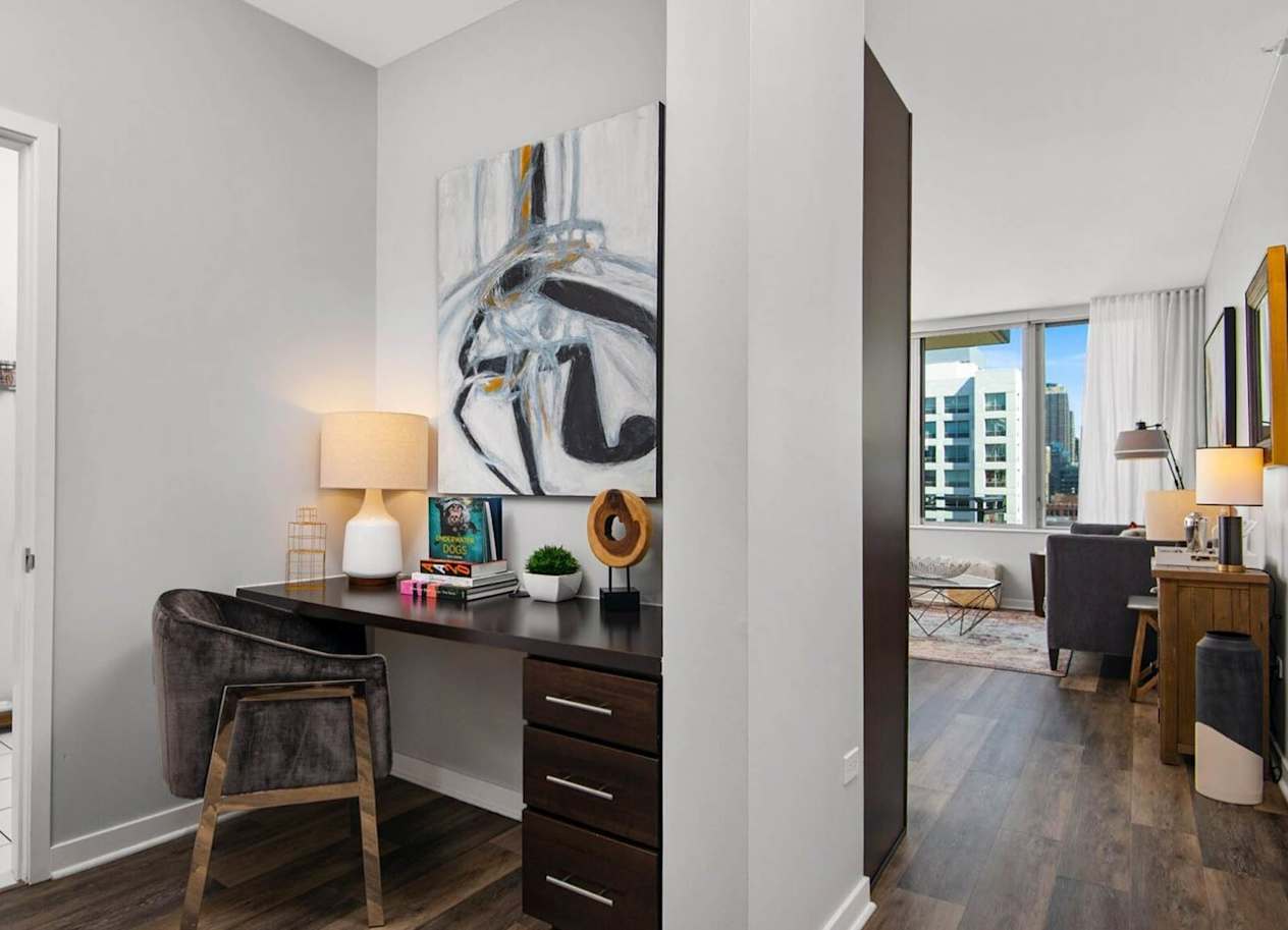 a desk with a chair and a lamp next to a washer and dryer
