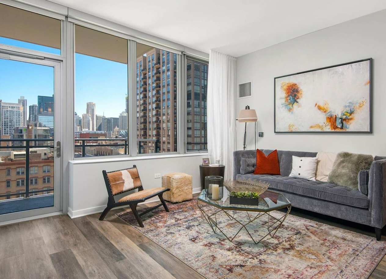 a living room with a large window and a door that leads to a balcony